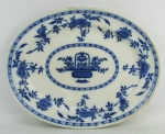 Antiga travessa oval em porcelana inglesa, com marca da manufatura Minton no verso. Decoração Delft de flores e folhagens no tom azul. Apresenta numeração e marca da manufatura a crivo no verso. Med. 38,5x30,5cm.