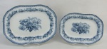 Duas travessas de coleção em porcelana inglesa, com marca da manufatura Copeland, decoradas com pintura floral e folhas em tons de azul. Med. 32x23,5 e 26x19cm.