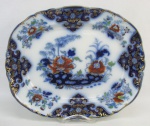 Belíssima e rara travessa de coleção, do séc. XIX, em porcelana azul borrão, decorada com pintura floral em policromia e detalhes em dourado. Med. 37,5x31cm.