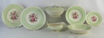 Aparelho de jantar em faiança inglesa, com marca da manufatura Windsor Ware Johnson Bros, decorados com faixa no tom verde e flores e folhas em policromia, composto de terrina com tampa, saladeira, legumeira, molheira, 10 pratos rasos, 8 fundos e 3 para sobremesa. Algumas peças com manchas causadas pelo tempo, saladeira com pequeno lascadinho na borda e molheira com pequenas perdas no esmalte. Med. terrina 11,5x26,5x24cm.