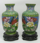 Par de vasos em cloisoné oriental, decorados com flores, folhagens, borboletas e arabescos em policromia. Bases em madeira entalhada. Alts. total 18,5cm.