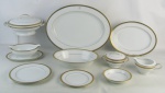 Aparelho de jantar em porcelana japonesa com marca da manufatura Noritake, decorada com frisos em dourado, composto de sopeira, 2 travessas, legumeira, 2 molheiras, 8 pratos rasos, 12 para salada, 12 fundos, 12 para sobremesa e 12 bowlzinhos. Três peças apresentam monograma. Total de 62 peças