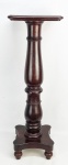 Coluna em madeira nobre maciça. Tampo retangular que se apoia sobre corpo torneado. Base com pés torneados. Med. 98,5x33x31,5cm.