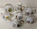 Jogo de 7 Miniaturas de bulês em porcelana com temas florais e temas religiosos  . A maior peça mede 6 cm