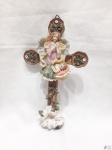 Crucifixo em resina trabalhada com imagem de anjo com Menino Jesus. Medindo 22cm x 12,5cm.
