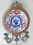 IMARI - Elegante girandole francês para três velas em bronze ormulu, estilo Rocaille, séc.XIX, tendo ao centro, belo prato em porcelana japonesa IMARI. (estrutura de encaixe). Medida do prato: 22 cm. Medida total: 38cm.