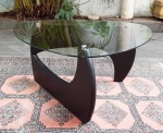 Mesa de apoio ao estilo Isamu Noguchi, (importante designer nipo-americano). Base em madeira na cor preta (desmontável) e tampo em vidro triangular. Medindo: 31 X 71cm.
