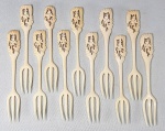 Lote com 11 antigos garfos chineses para petiscos em marfim ou osso, cabo decorado com figura de pássaro e flor. Med. 13 cm.