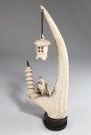 Escultura oriental em marfinite no formato de chifre com pagode, lanterna e veados. Base em madeira. Med. 21 cm.