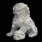 Cão de Fó em porcelana oriental branca. Medida 12,5 cm de altura.