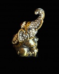 Bibelô em metal dourado na forma de elefante com pedras cravejadas e ricos acabamentos. Medida 8 cm de altura.