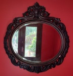 Belíssimo espelho em cristal bisotado com moldura em madeira nobre, ricamente entalhado no formato oval, encimado com florão - mede 101 cm de altura e 96 cm de largura.