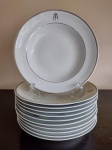 Lote composto de 11 pratos fundos em porcelana branca com monograma JM. Friso prateado na borda - mede 23 cm de diâmetro.