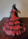 Escultura em plástico rígido representando uma cigana com leque na mão, tiara e véu na cabeça - mede 31 cm de altura.