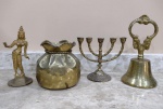 Lote composto de quatro itens em bronze metal amarelo sendo saco da fortuna, um mini castiçal judaico (menorah), um sino e uma escultura representando uma egípcia - mede o maior 15 cm de altura.
