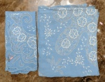 Dois itens sendo uma toalha para mesa de jantar bordada a máquina em linho na cor azul e um centro de mesa no mesmo padrão - mede a toalha 2,00 m de comprimento 150 de largura, o centro de mesa mede 86x86 (formato quadrado).