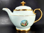 PORCELANA REAL - Lindo bule para chá em porcelana branca decorada por pintura em ouro e cena idílica em policromia. Mede 17 cm de altura por 21,5 cm da alça ao bico.