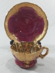Mini xícara para café de coleção em porcelana com pintura em ouro (inclusive no interior da xícara) sobre tom bordô. Mede 3,1 x 4,8 cm a xícara e 9,2 cm de diâmetro os pires. 