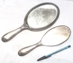 Par de belos espelhos de mão, com bela decoração floral produzidos em metal espessurado a prata, maior comprimento 27cm, princípio e meados do século XX.