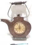 Antigo relógio de mesa com estrutura produzida em madeira, representando bule, com funcionamento a corda, numerais em algarismos romanos, altura total 31cm, não funciona.