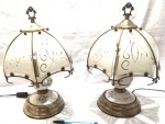 Par de belos abajours de cabeceira, com estrututra produzida em porcelana, e cúpulas produzidas em vidro, com bela decoração floral e guarnições metálicas, altura 36cm, não testados, fiação no estado.