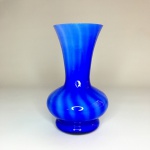 Gracioso vaso em vidro na cor azul rematado com linhas verticais em tom claro. Exemplar em excelente estado. Dimensões: 16 cm x 10 cm.