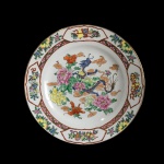 Prato em fina porcelana de origem Oriental, decorado com figura de dragão e arranjos florais. Exemplar de coleção e em excelente estado. Dimensões: 26 cm.