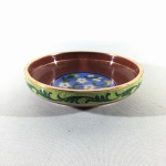 ARTE ORIENTAL - Antigo bowl CLOISONNÉ esmaltado, decorado comarranjo floral ao centro sobre fundo azul claro, ladeado por faixa vermelha e estilzados. Exemplar de coleção. Dimensões: 12 cm x 2,5 cm. A técnica Cloisonné é de origem Bizantina e foi introduzida na China no século XIV / Dinastia Ming. Sobre um objeto fabricado em metal, geralmente em cobre, aplicava-se um conjunto de finos fios dourados formando os contornos dos motivos desejados. Os favos, ou "cloisons", eram depois preenchidos com esmaltes coloridos, fortemente comprimidos e polidos até atingirem o acabamento desejado.