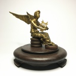 Antiga escultura "Anjo com harpa" em bronze sobre base circular em madeira. Exemplar rico em detalhes e em excelente estado. Dimensões: 18 cm x 19 cm x 19 cm.