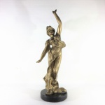 Belíssima e robusta estatueta de " Figura feminina" em metal cinzelado e patinado de dourado sobre base circular em mármore preto e polido. Exemplar em excelente estado. Dimensões: 41 cm / 1800 g.