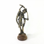 Escultura em metal cinzelado revestido de dourado representando Oriental e sua espada. Base circular em madeira. Exemplar em excelente estado. Dimensões: 23 cm altura.