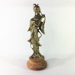 Escultura em metal cinzelado revestido de dourado representando Oriental tocando sua cítara. Base circular em madeira. Exemplar em escelente estado. Dimensões: 21 cm altura.