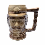 Antiga e robusta caneca em cerâmica esmaltada e vitrificada representando figura masculina com cachimbo. Numeração no fundo " 1.108". Exemplar de coleção e em perfeito estado de conservação. Dimensões: 16 cm x 15 cm.