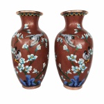 Imponente e antigo par de vasos Cloisonné, de origem Oriental, rematados com pássaros e arranjos Florais nas cores branco e azul sobre fundo Grená.  Exemplar de coleção e em excelente estado. Dimensões: 31 cm  x 16 cm.  A técnica cloisonné é de origem bizantina e foi introduzida na China no século XIV / Dinastia Ming.  Sobre um objeto fabricado em metal, geralmente em cobre, aplicava-se um conjunto de finos fios dourados formando os contornos dos motivos desejados. Os favos, ou "cloisons", eram depois preenchidos com esmaltes coloridos, fortemente comprimidos e polidos até atingirem o acabamento desejado.