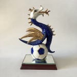 "Delicada e exuberante estatueta em fina porcelana Européia de ""Dragão"" Mascote do Futebol Clube do Porto. Base em madeira e espelho. Ricos detalhes pintados à Ouro 22 k. Dimensões: 22 cm."