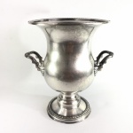 EBERLE - Antigo vaso Ânfora em metal cinzelado espessurado à prata, decorado com faixas peroladas e alças no formato de folhas de acanto. Presença de pequena mossa no bojo. Dimensões: 24,5 cm x 22 cm.