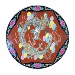 ARTE ORIENTAL - Belo e antigo medalhão em porcelana esmaltada, decorado com figura de dragão, ladeado por arranjos florais sofre fundo vermelho e preto. Exemplar possivelmente do séc XIX. Dimensões: 39 cm x 5 cm.