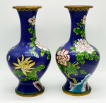 Imponente e antigo par de vasos Cloisonné, de origem Oriental, rematados com  peônias, crisântemos, cerejeiras e borboletas sobre fundo azul royal.  Exemplar de coleção e em excelente estado. Dimensões: 38 cm.  A técnica cloisonné é de origem bizantina e foi introduzida na China no século XIV / Dinastia Ming.  Sobre um objeto fabricado em metal, geralmente em cobre, aplicava-se um conjunto de finos fios dourados formando os contornos dos motivos desejados. Os favos, ou "cloisons", eram depois preenchidos com esmaltes coloridos, fortemente comprimidos e polidos até atingirem o acabamento desejado.