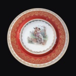 BAVÁRIA - Luxuoso prato em fina porcelana ALEMÃ, possivelmente anos 60, esmaltada em tom de vermelho decorado com cena de NINFA E QUERUBIM. Ricos detalhes pintados à Ouro. Exemplar de coleção e em excelente estado. Pequenos desgastes por conta do tempo. Dimensões: 25,5 cm diâmetro.