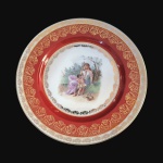 BAVÁRIA - Luxuoso prato em fina porcelana ALEMÃ, possivelmente anos 60, esmaltada em tom de vermelho decorado com cena de NINFA E QUERUBIM. Ricos detalhes pintados à Ouro. Exemplar de coleção e em excelente estado. Pequenos desgastes por conta do tempo. Dimensões: 25,5 cm diâmetro.