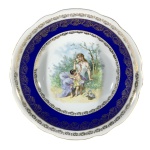 BAVÁRIA - Antiga e suntuosa saladeira em fina porcelana Alemã decorada ao centro com "Damas e Querubins no Jardim" e ladeada por larga faixa na cor verde. Borda ondulada e detalhes gravados à Ouro 22k. Exemplar de coleção e em excelente estado. Dimensões:  26 cm x 7 cm.