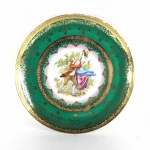 PORCELANA DP - Elegante Prato de coleção em porcelana esmaltada, em tons de verde, decorado com cena galante ao centro e detalhes em arabescos e faixas circulares gravadas à Ouro 22k. Borda com  desgaste na pintura. Dimensões: 25 cm diâmetro.