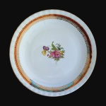 STEATITA - Elegante prato em porcelana, anos 70, decorado com arranjo floral ao centro e ladeado por faixa na cor rubi com belíssimos realces à Ouro. Dimensões: 21 cm.