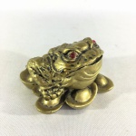 ARTE ORIENTAL - Sapo de três pernas da sorte " Chan Chu" com olhos vermelhos e narinas flamejantes. Estatueta em resina revestida de dourado. Dimensões: 5 cm x 8 cm x 8 cm.