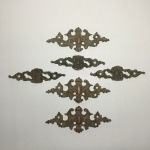 Conjunto com 6 apliques em bronze para móveis decorados com folhas de acanto. Dimensões: 14,5 cm x 6 cm e 12,5 cm e 3,5 cm.