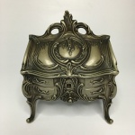 FRANCE - Antigo porta-joias em metal cinzelado no formato de Cômoda Luís XV. Ricos detalhes. Parte interna em veludo na cor vermelho. Dimensões: 13,5 cm 7,5 cm 12,5 cm / 630 g.