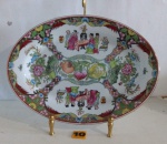 CHINA - Travessa de coleção em fina porcelana, decorada com cena tradicional Chinês intercalados por frutos e arranjos florais. Exemplar em excelente estado. Dimensões: 30x22 cm.