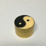 Porta comprimidos oriental em metal dourado com símbolo Yin Yang. Dimensões:  2 cm x 3 cm.