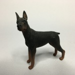 Dobermann em material emborrachado, resistente, rico em detalhes. Parte de coleção. Dimensões: 8 cm x 8 cm x 2,5 cm.