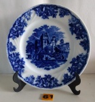 VISTA ALEGRE - Prato de coleção em fina porcelana PORTUGUESA com esmaltagem vitrificada, dita "BORRÃO AZUL" rematado em sua galeria central por castelo e borda com ornada por padrões e segmentos florais. Medindo 22 cm.